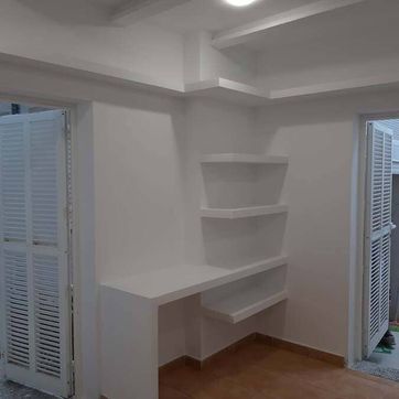 Una habitación con un escritorio y estantes.