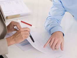 Gespräch am Schreibtisch zwischen Pfleger und Patientin