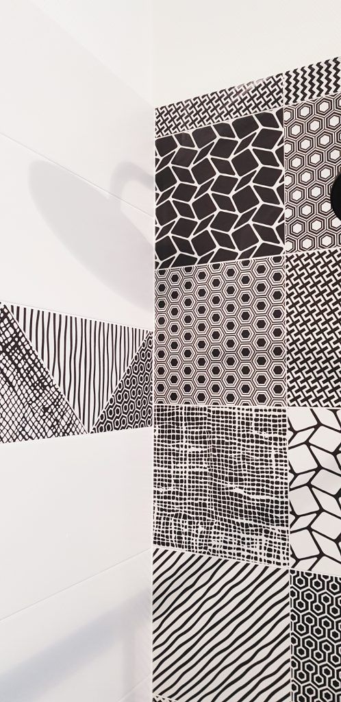 Motif textile géométrique abstrait noir et blanc avec rayures répétitives et sections en mosaïque