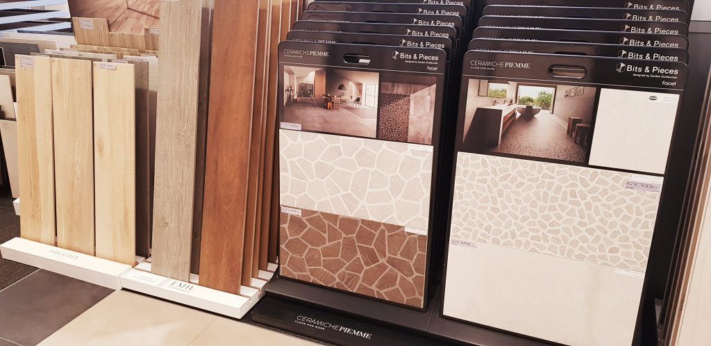 Présentation en magasin d'échantillons de revêtements de sol et de carreaux décoratifs aux tons neutres