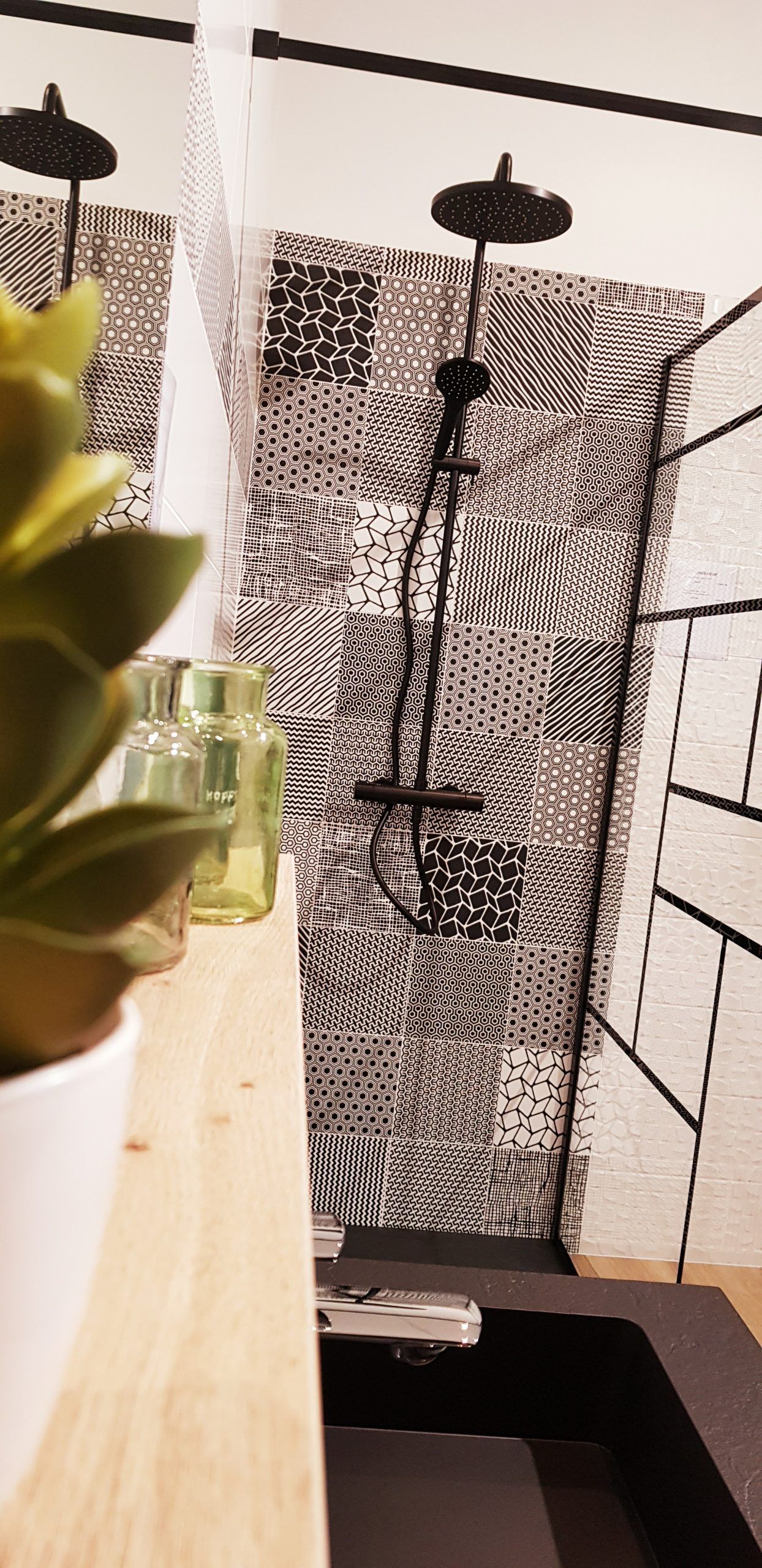 Deux rideaux de douche à motifs noirs et blancs dans une salle de bains avec une baignoire et une étagère au premier plan