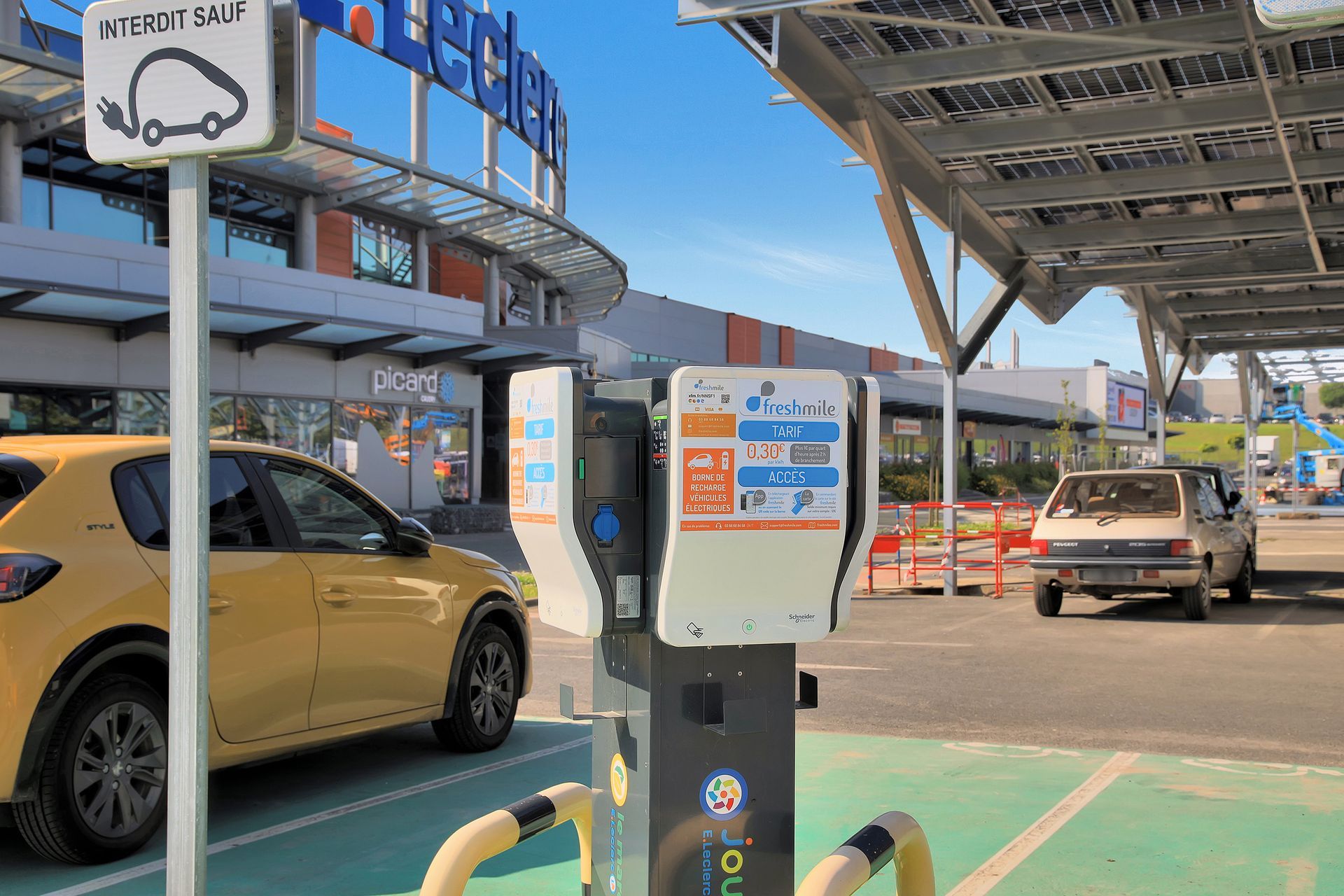 Une voiture raccordée à une borne de recharge électrique