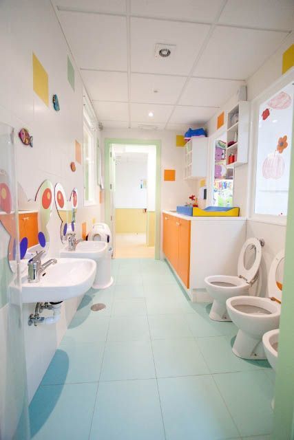 Un baño con una fila de lavabos e inodoros.