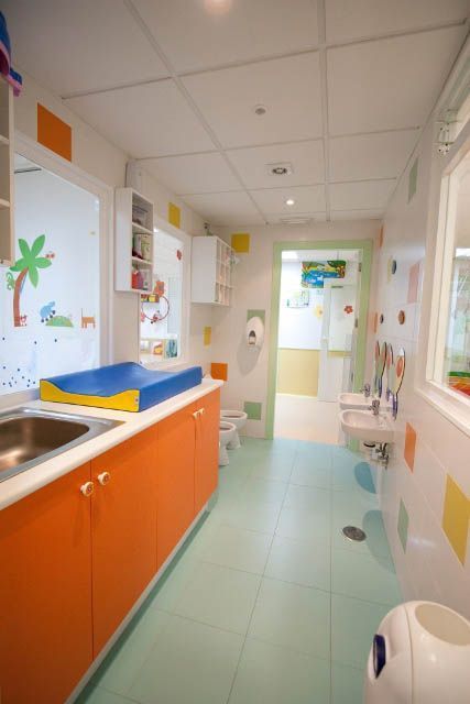 Un baño con armarios de color naranja y un cambiador.