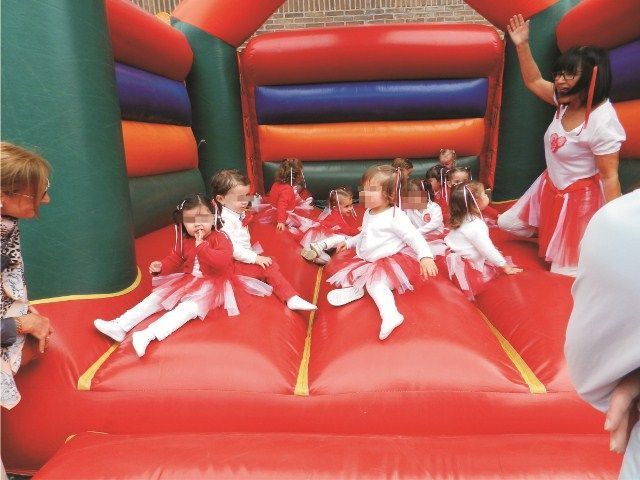 Un grupo de niñas están jugando en una casa inflable.