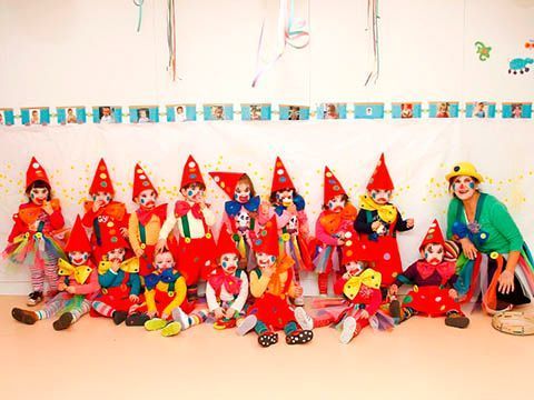 Un grupo de niños vestidos de payasos posan para una fotografía.