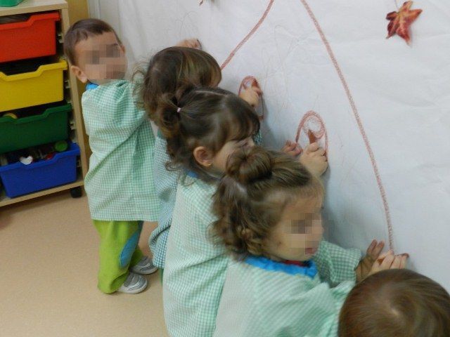 Un grupo de niños está dibujando en una pizarra blanca.