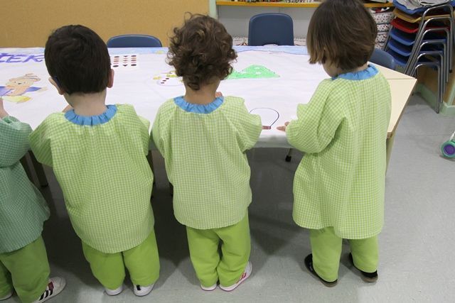 Un grupo de niños de pie frente a una mesa con números.
