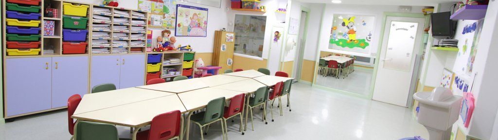 Un aula con una mesa larga y sillas.