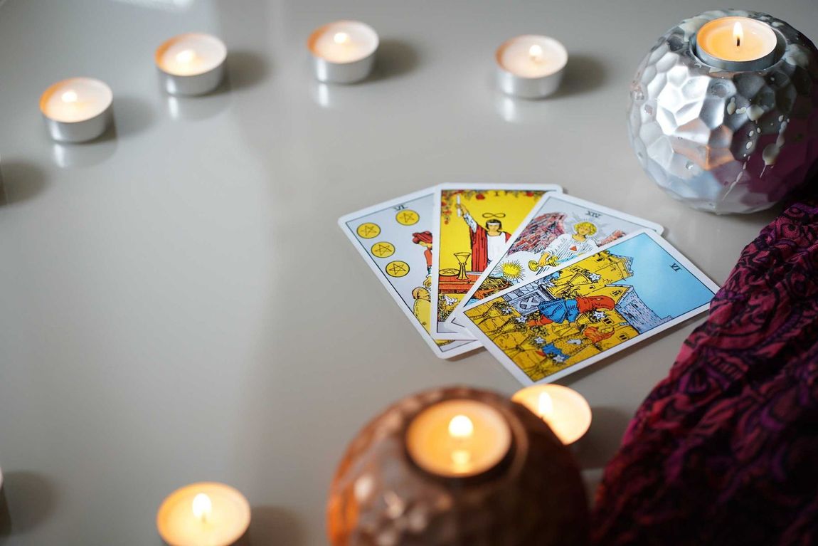 Las cartas del tarot están sobre una mesa junto a velas.