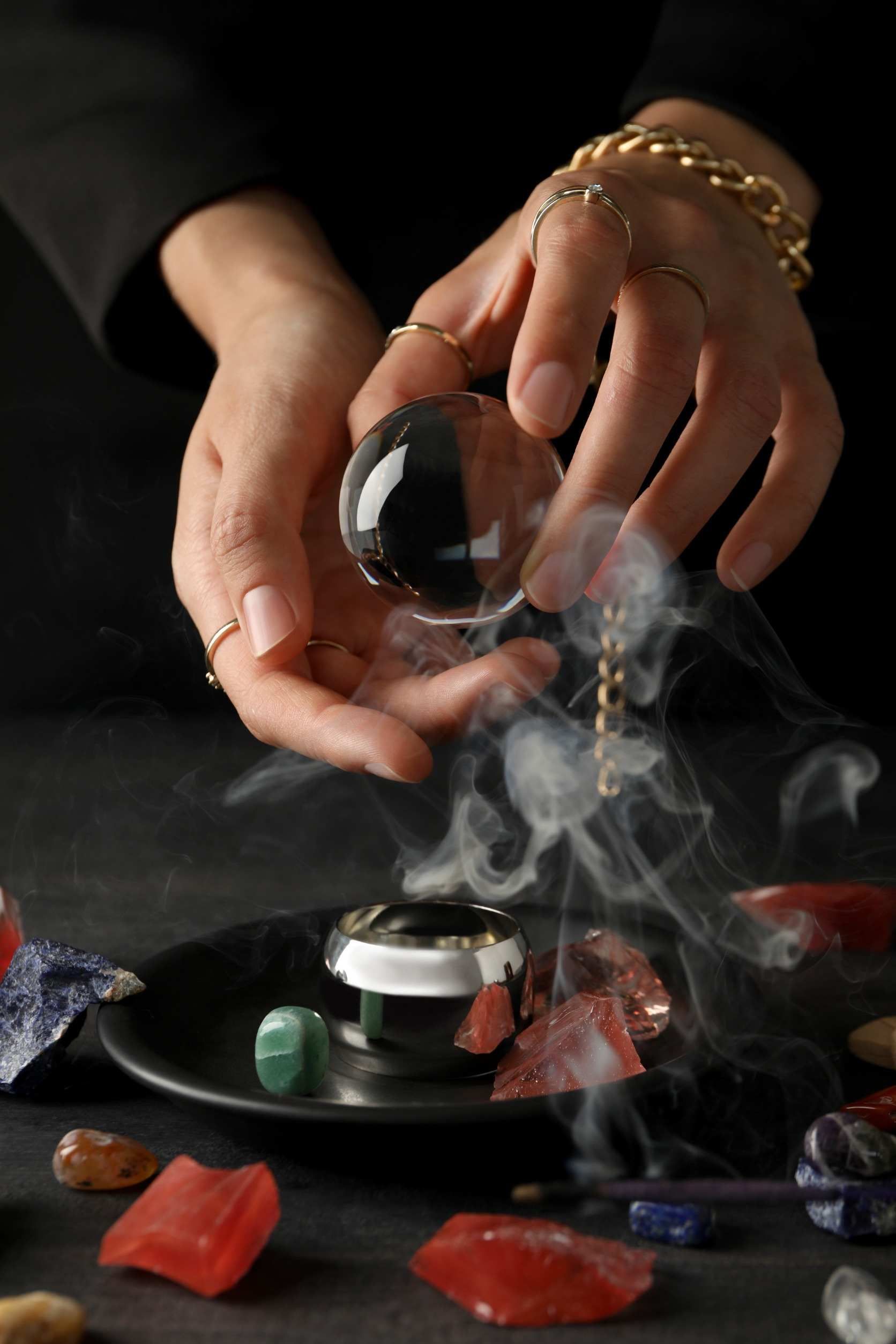 Una persona sostiene un cristal en sus manos del que sale humo.