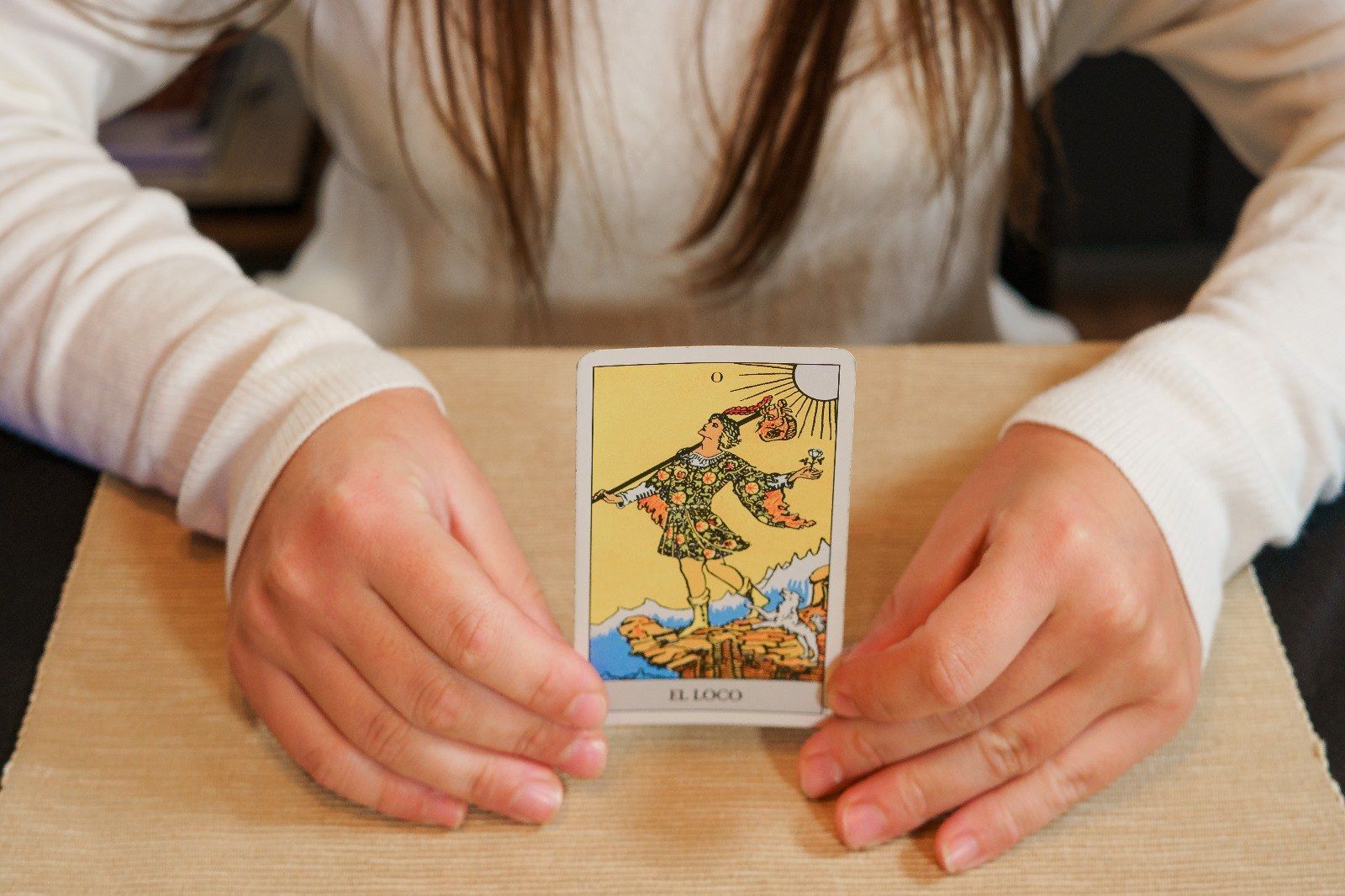 Una mujer sostiene una carta del tarot en sus manos.