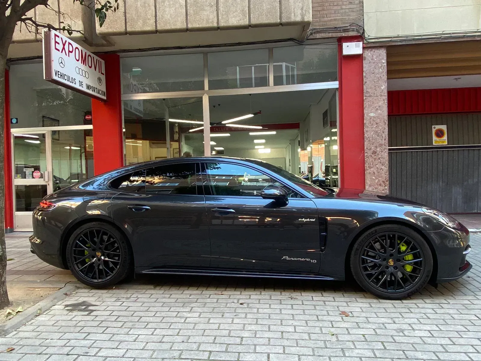 Un coche deportivo negro está aparcado delante de un edificio.