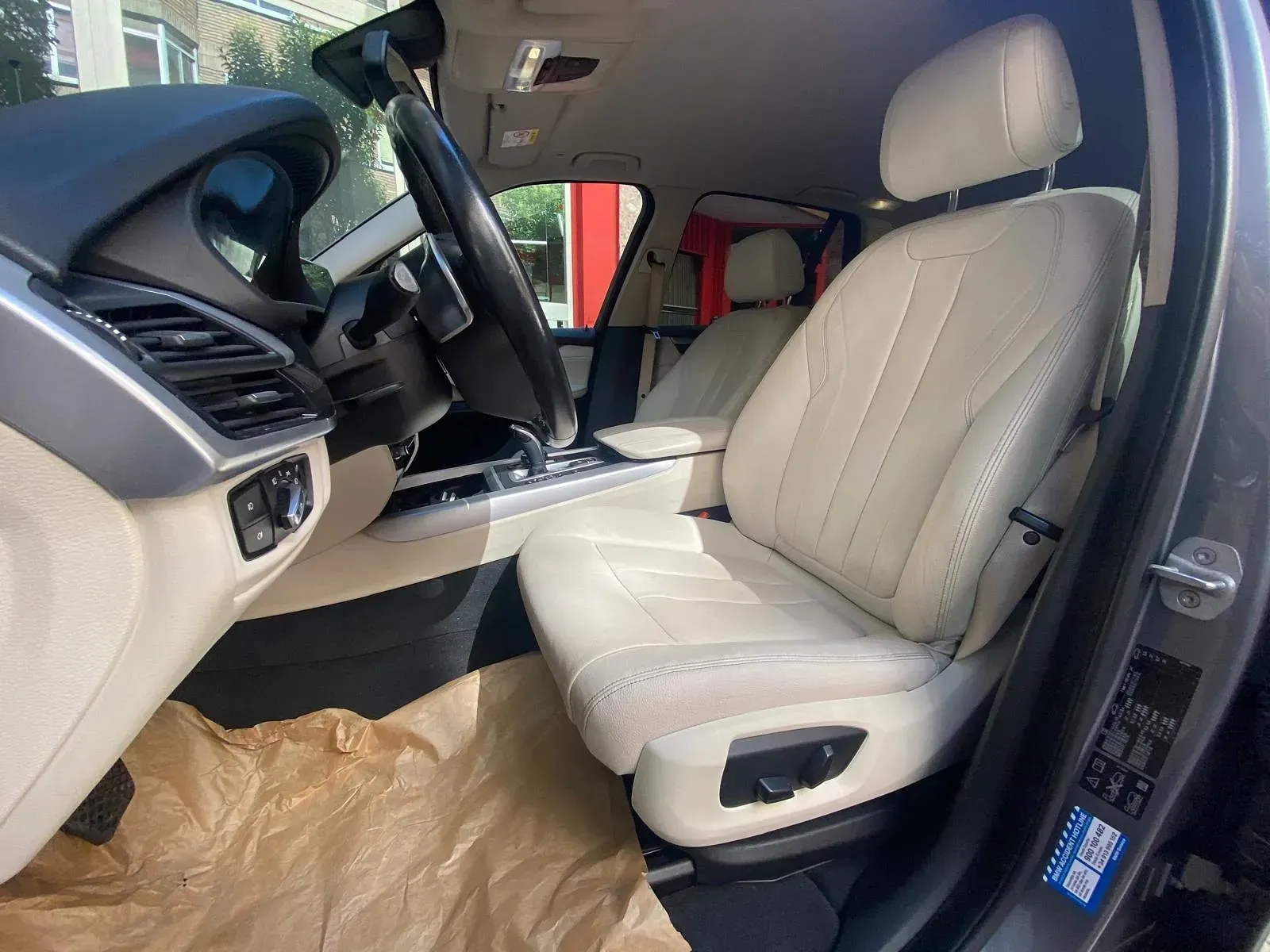 El interior de un coche con asientos de cuero blanco y un volante.