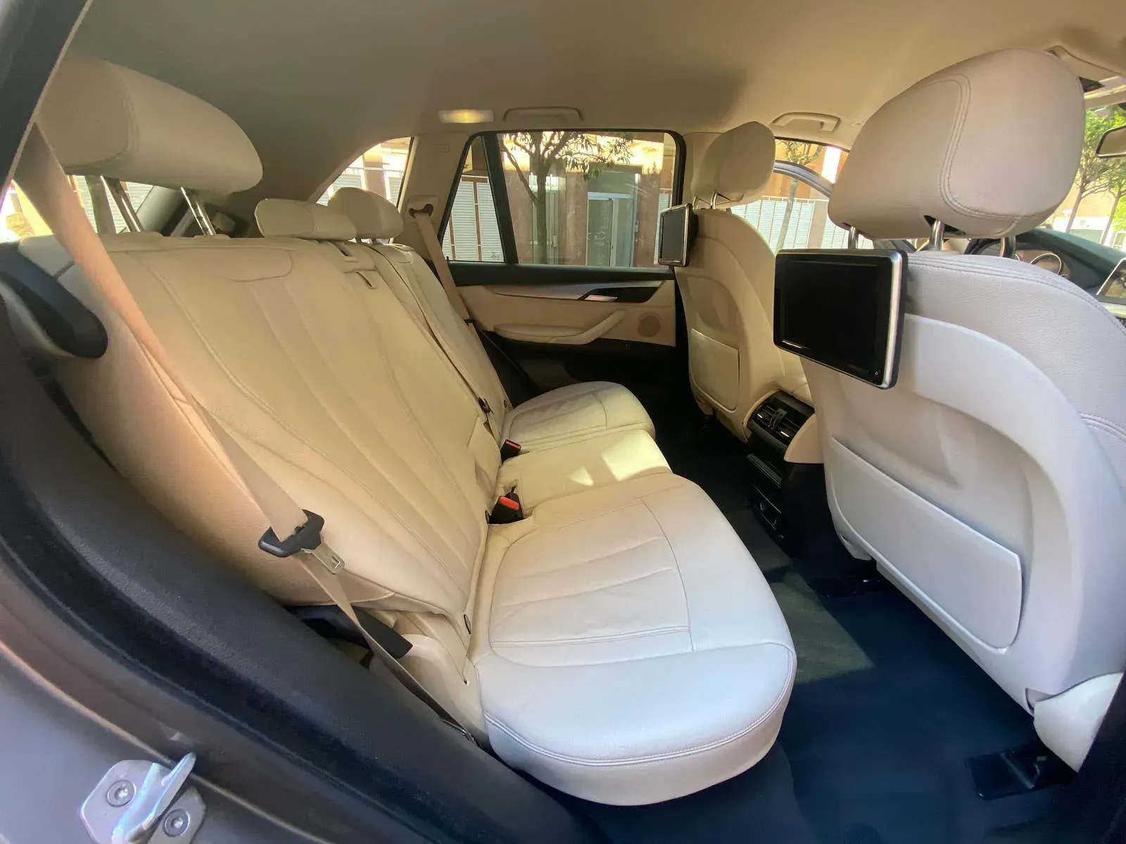El asiento trasero de un BMW X5 con asientos de cuero blanco.