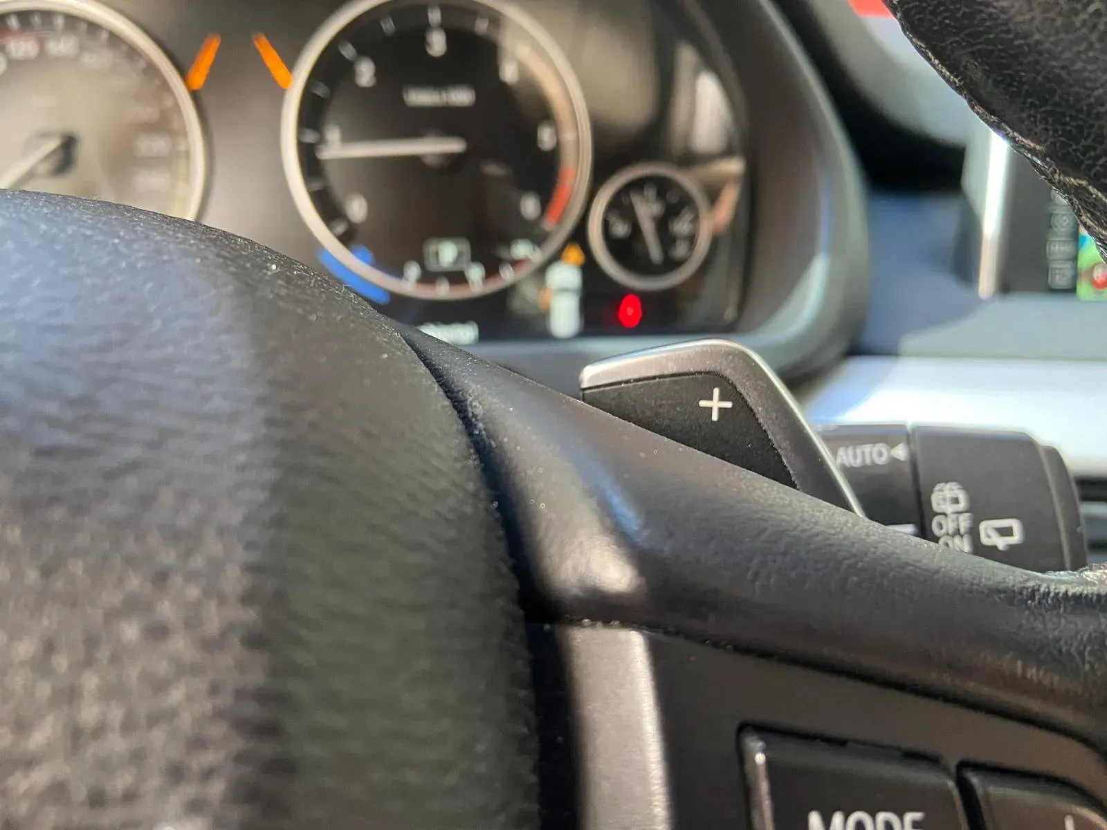 Un primer plano del volante de un automóvil con un botón de modo.