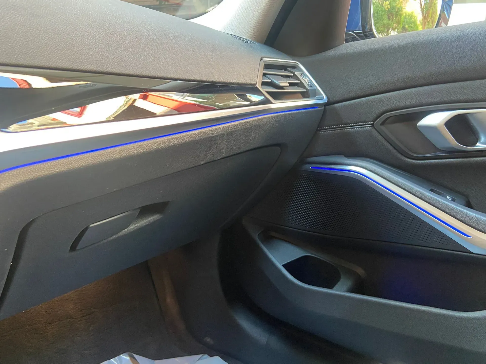 El interior de un coche con una luz azul en la puerta.