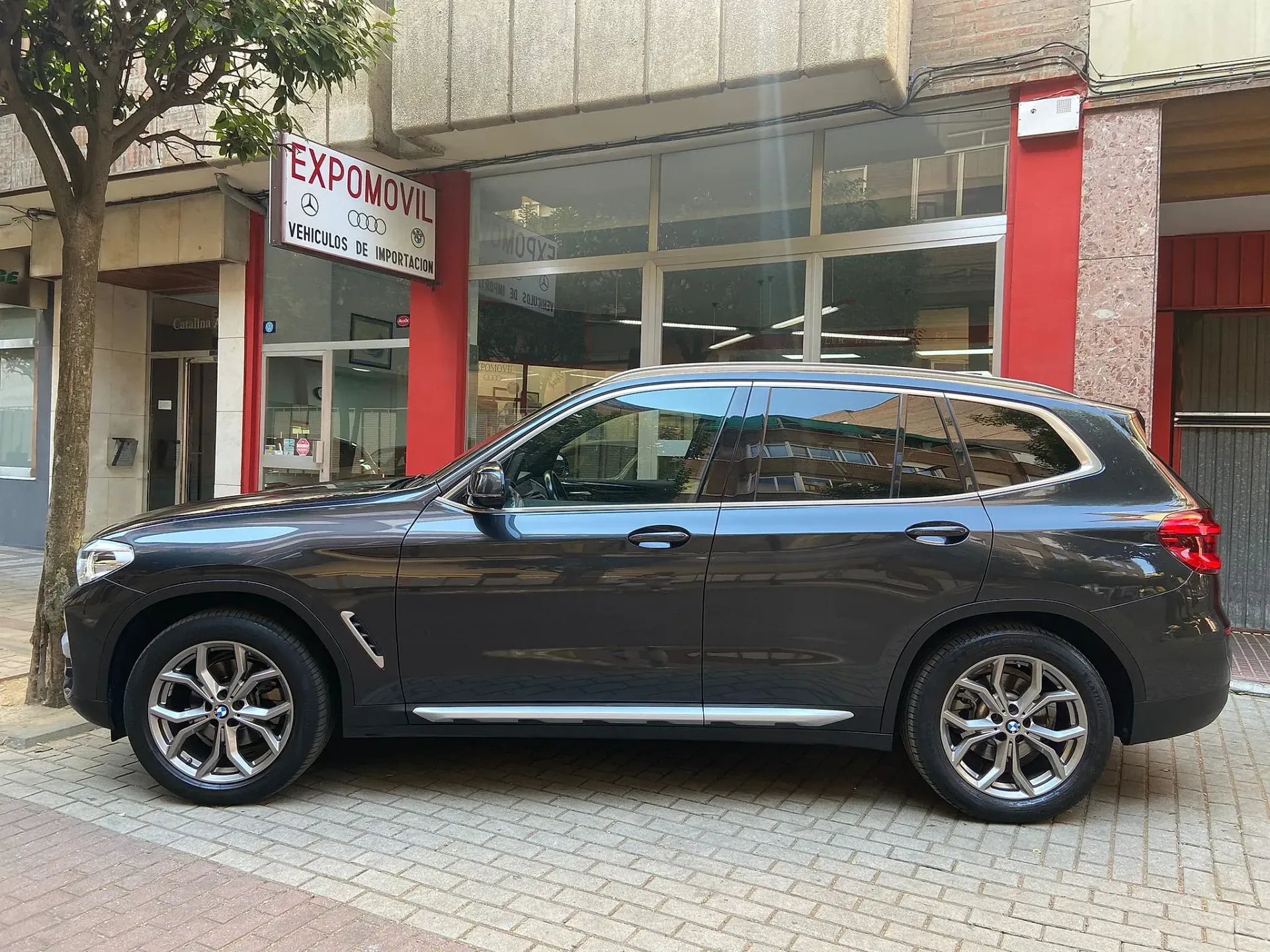 Un todoterreno negro está estacionado frente a un edificio.