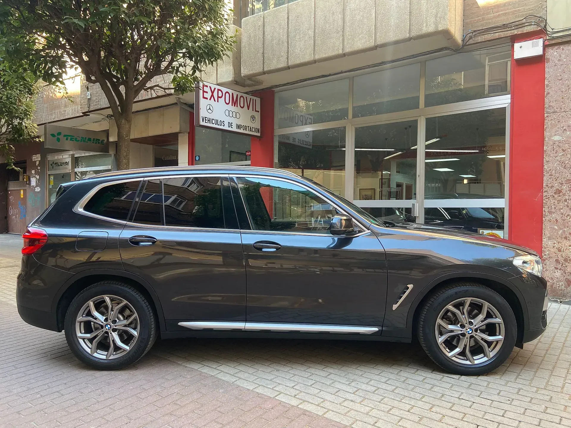 Un todoterreno negro está estacionado frente a un edificio.