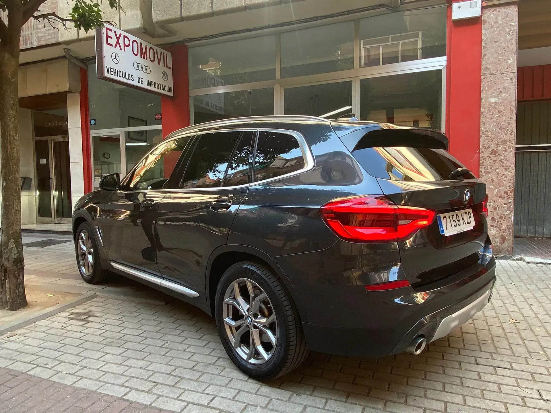 Un BMW X3 negro está estacionado frente a un edificio.