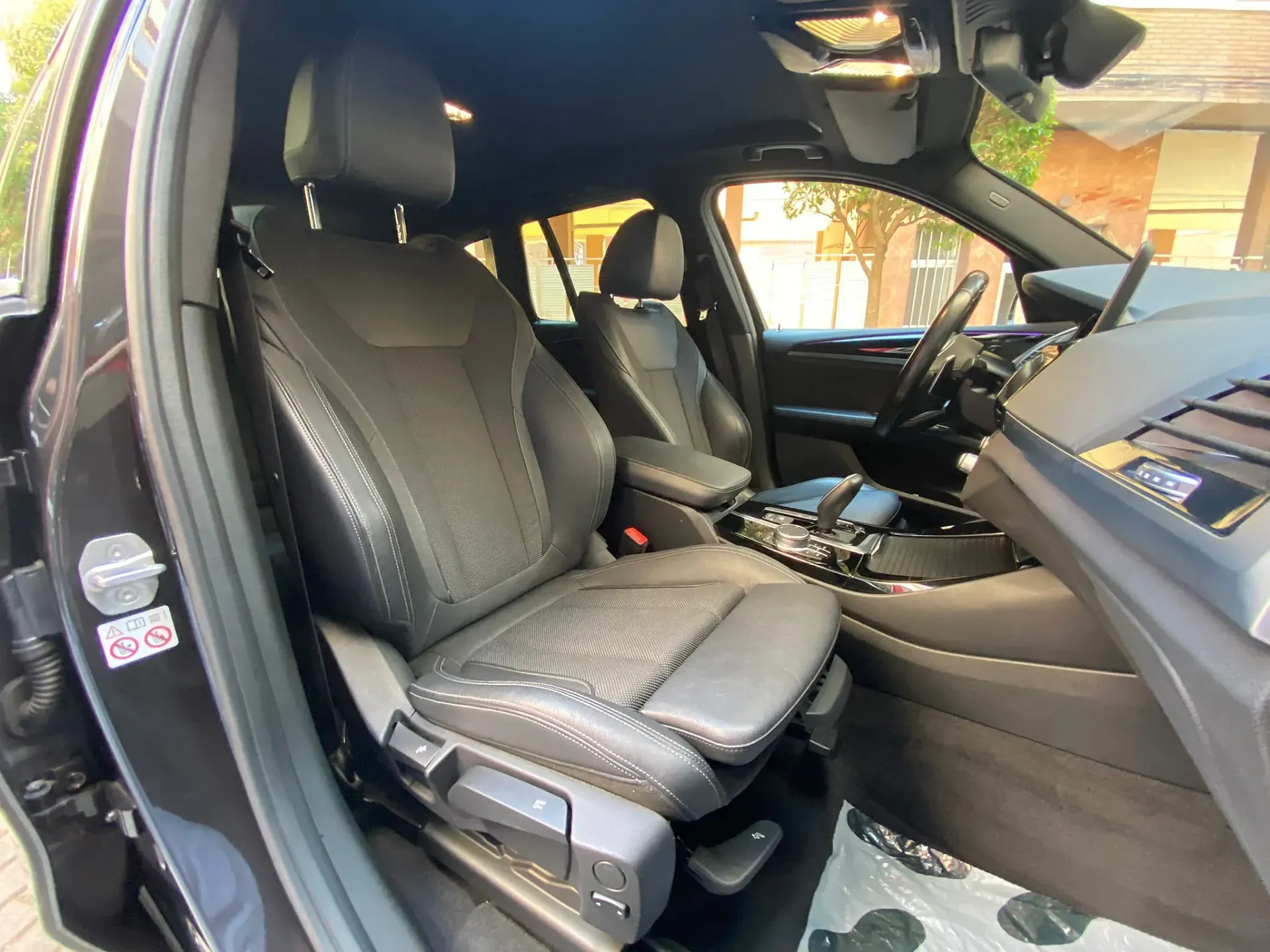 El interior de un coche negro con asientos de cuero y volante.