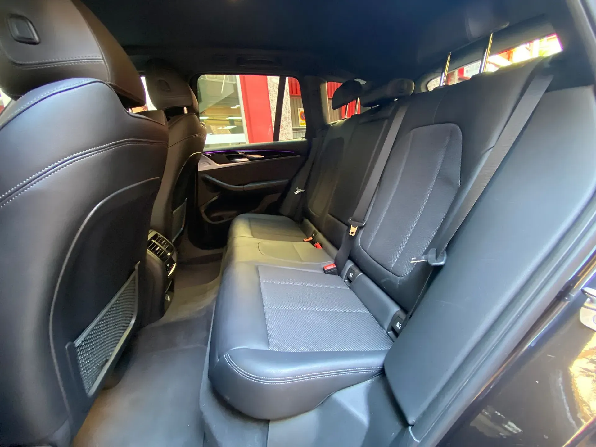 Los asientos traseros de un coche negro están vacíos.