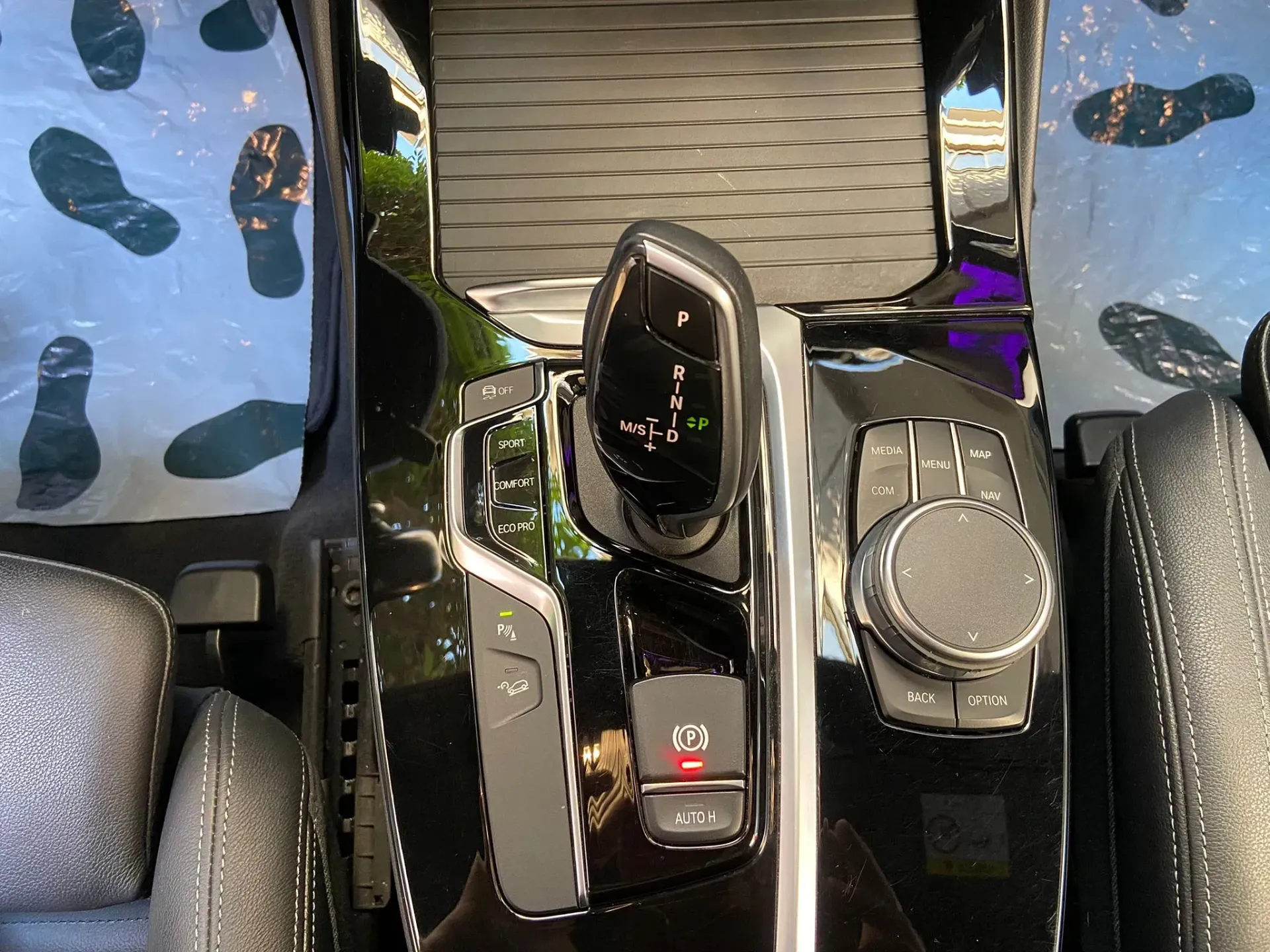 Un primer plano del tablero de instrumentos de un automóvil con huellas en el suelo.