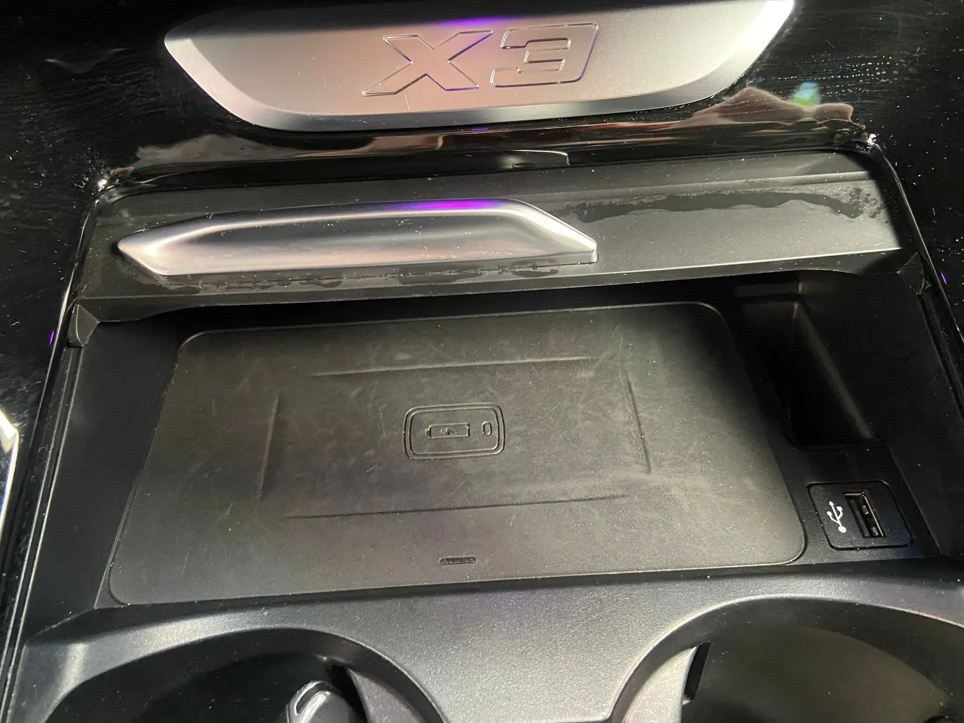 Un cargador inalámbrico está ubicado debajo de un portavasos en un automóvil.