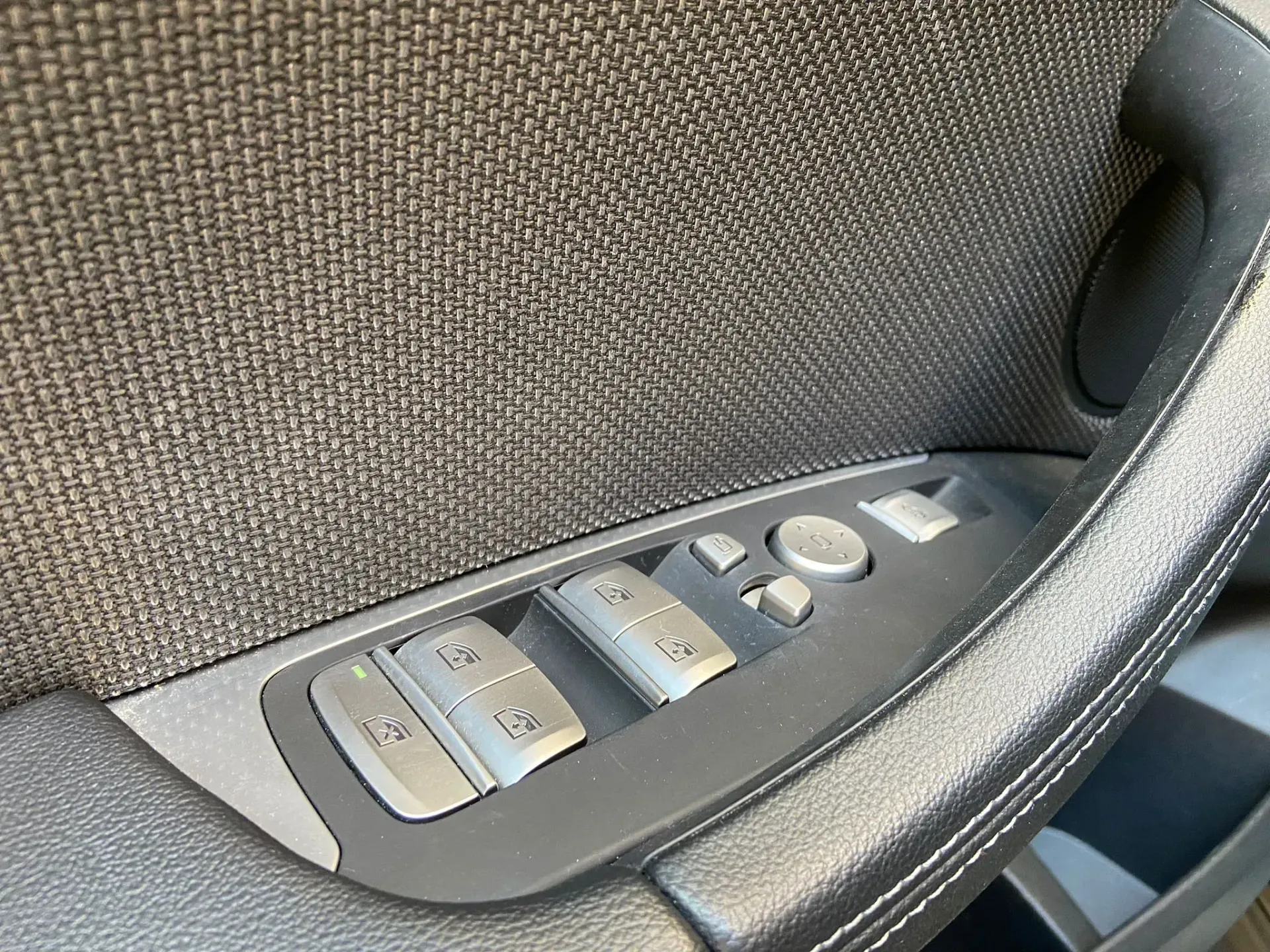 Un primer plano de la manija de la puerta de un automóvil con botones.