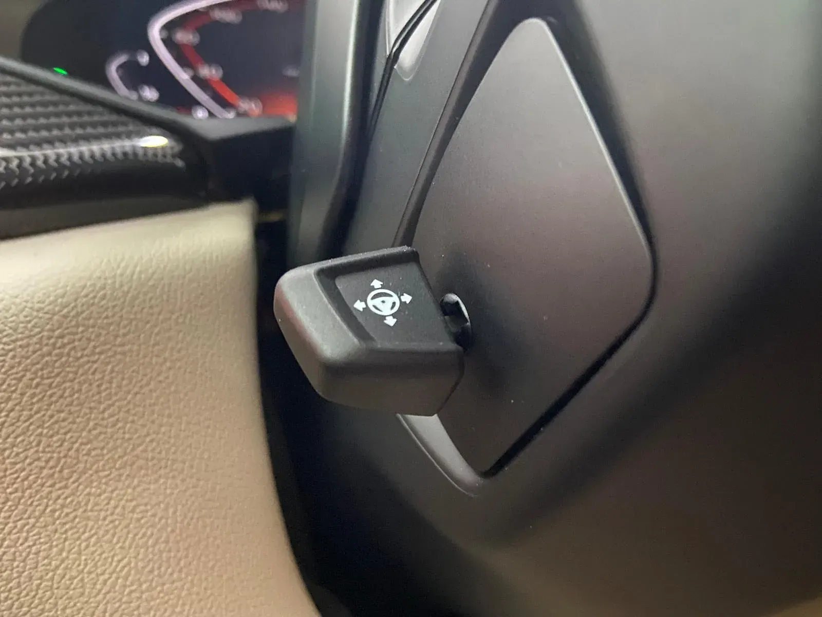 Un primer plano del volante de un automóvil con un botón.