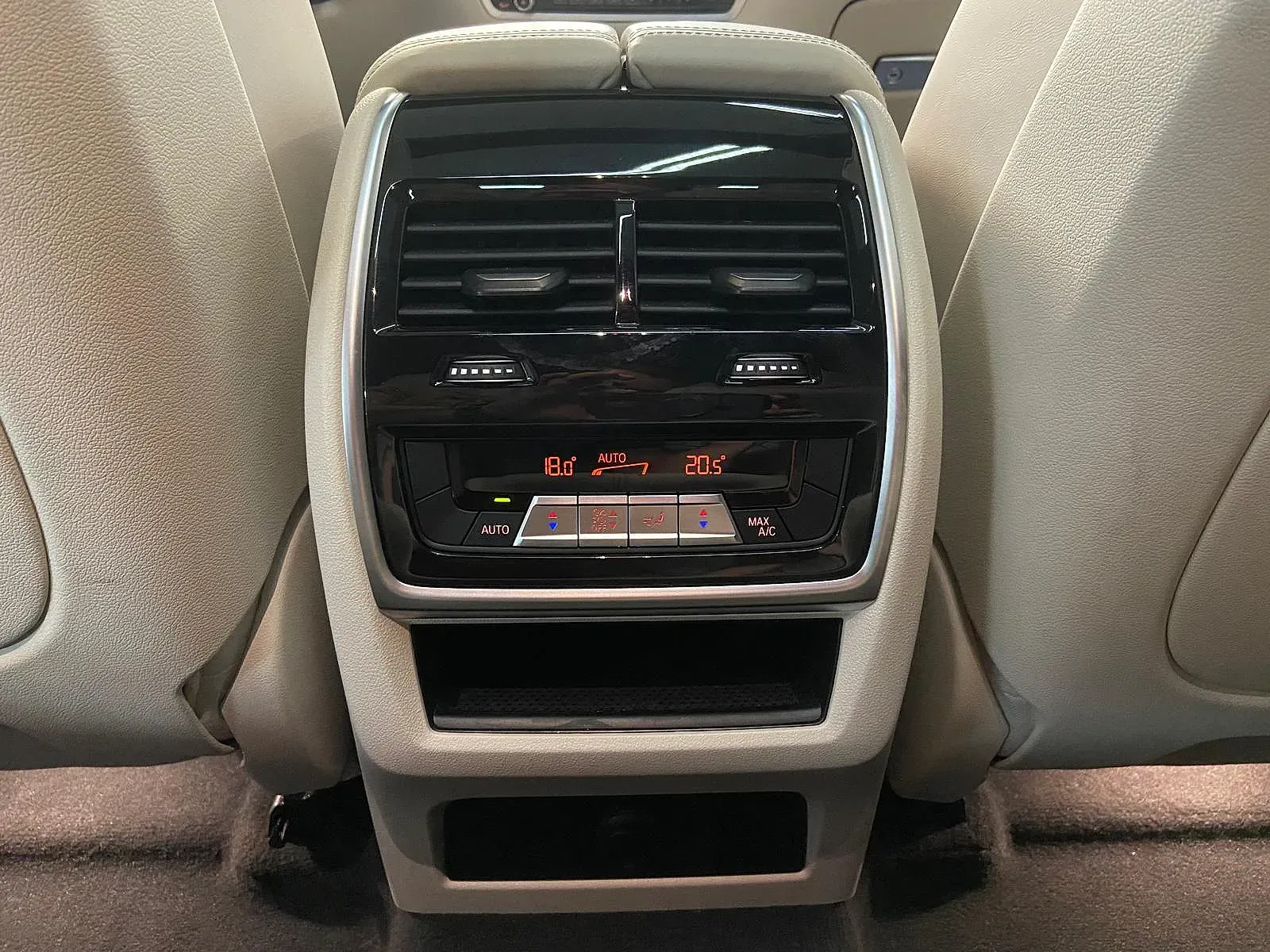 El asiento trasero de un coche con control de climatización y reproductor de CD.