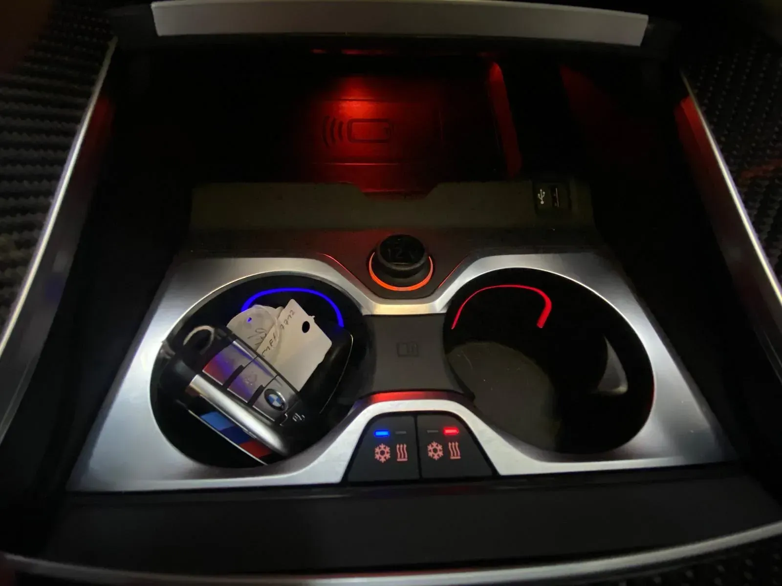 Un teléfono celular está sentado en un portavasos en un automóvil.