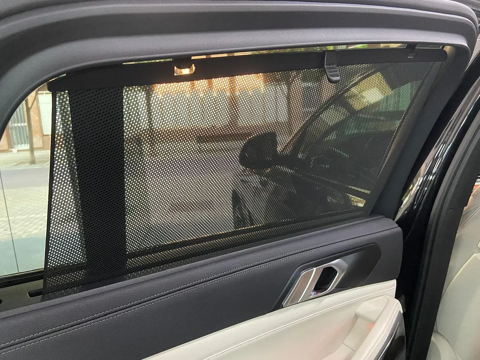 Un coche con una malla en la ventana trasera.