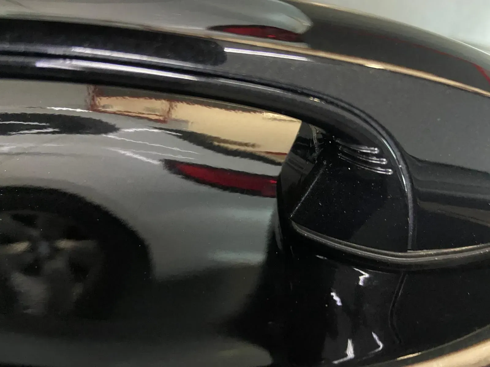 Un primer plano del espejo lateral de un automóvil con un reflejo de un automóvil en él.