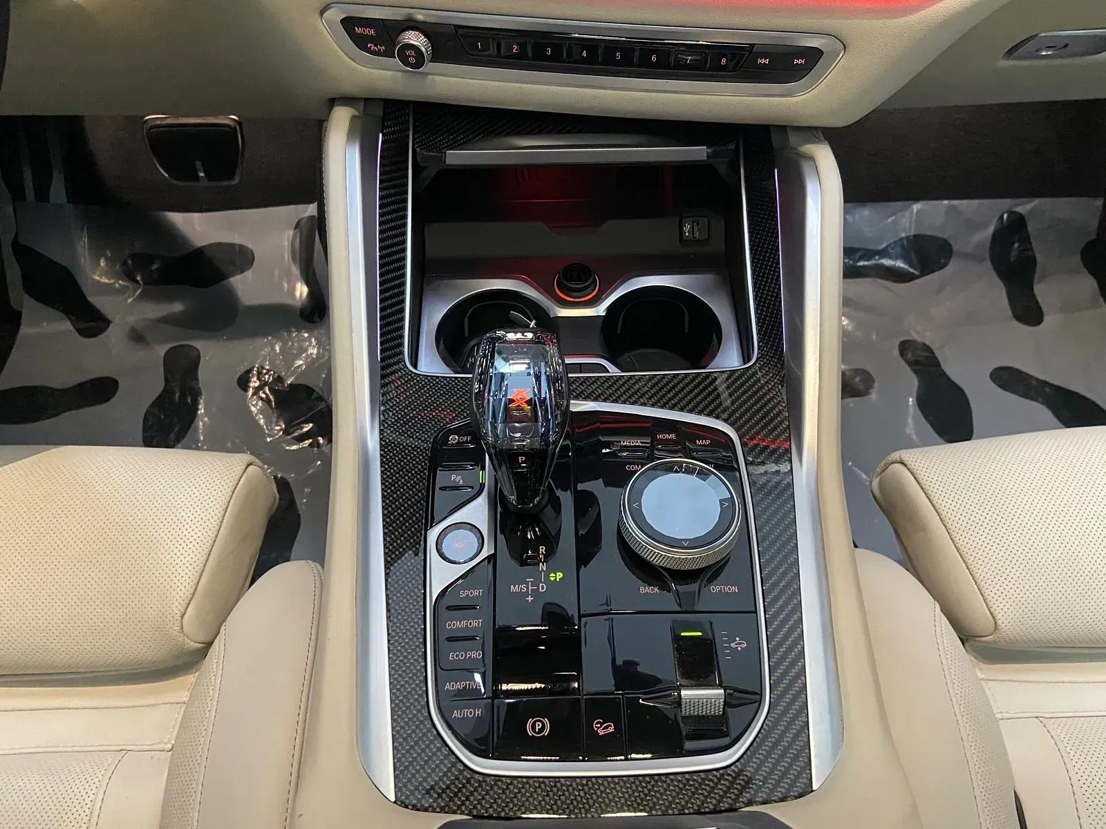 El tablero de instrumentos de un automóvil con una palanca de cambios y un portavasos.