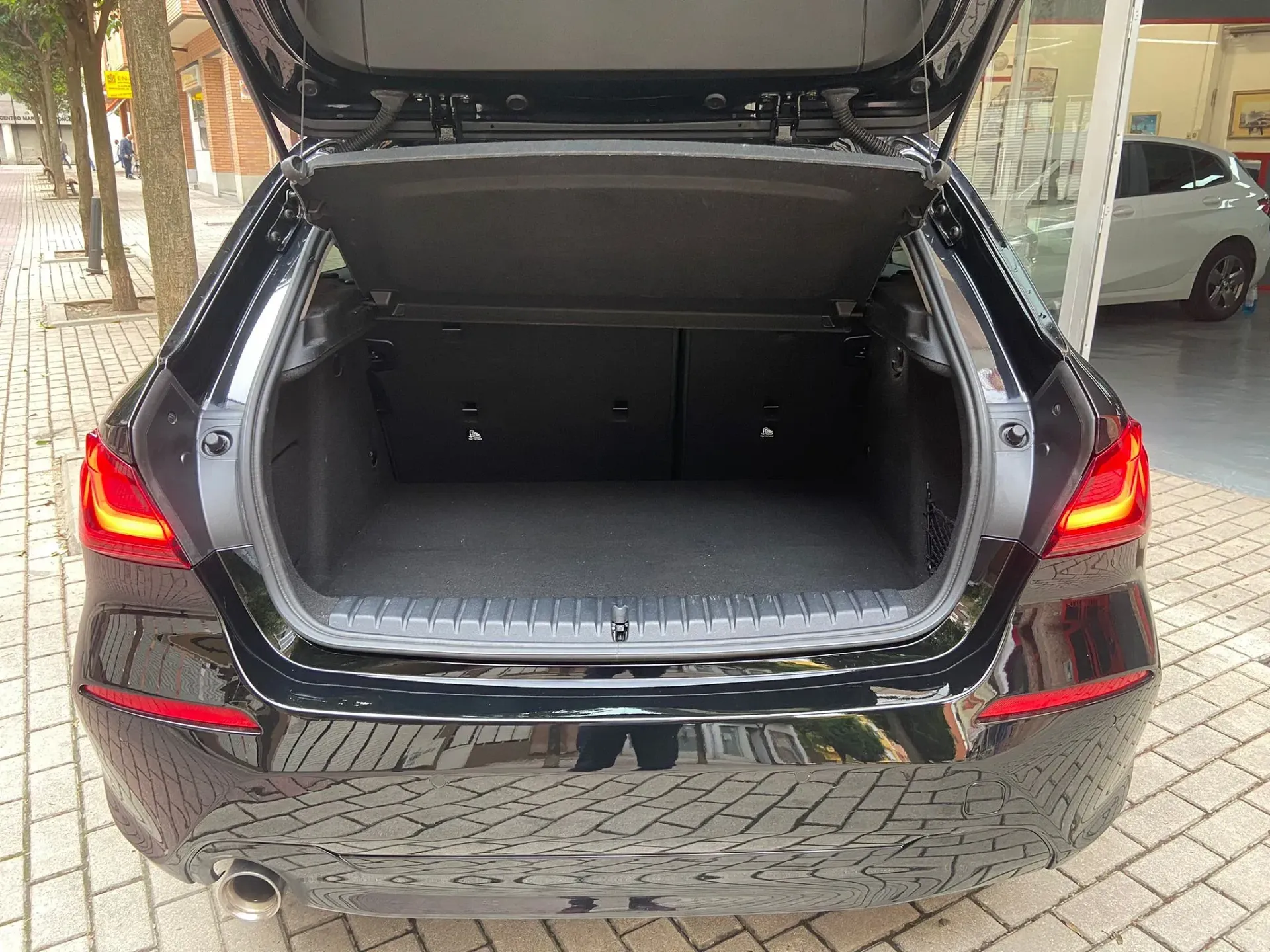 El maletero de un coche negro está abierto y vacío.