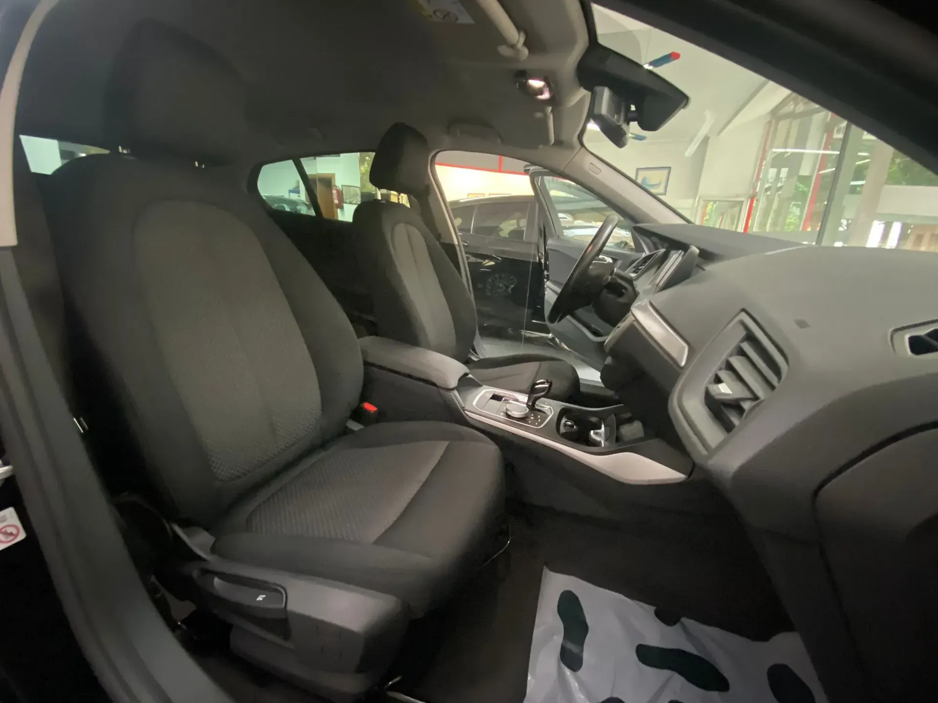 El interior de un coche con la puerta abierta y los asientos levantados.
