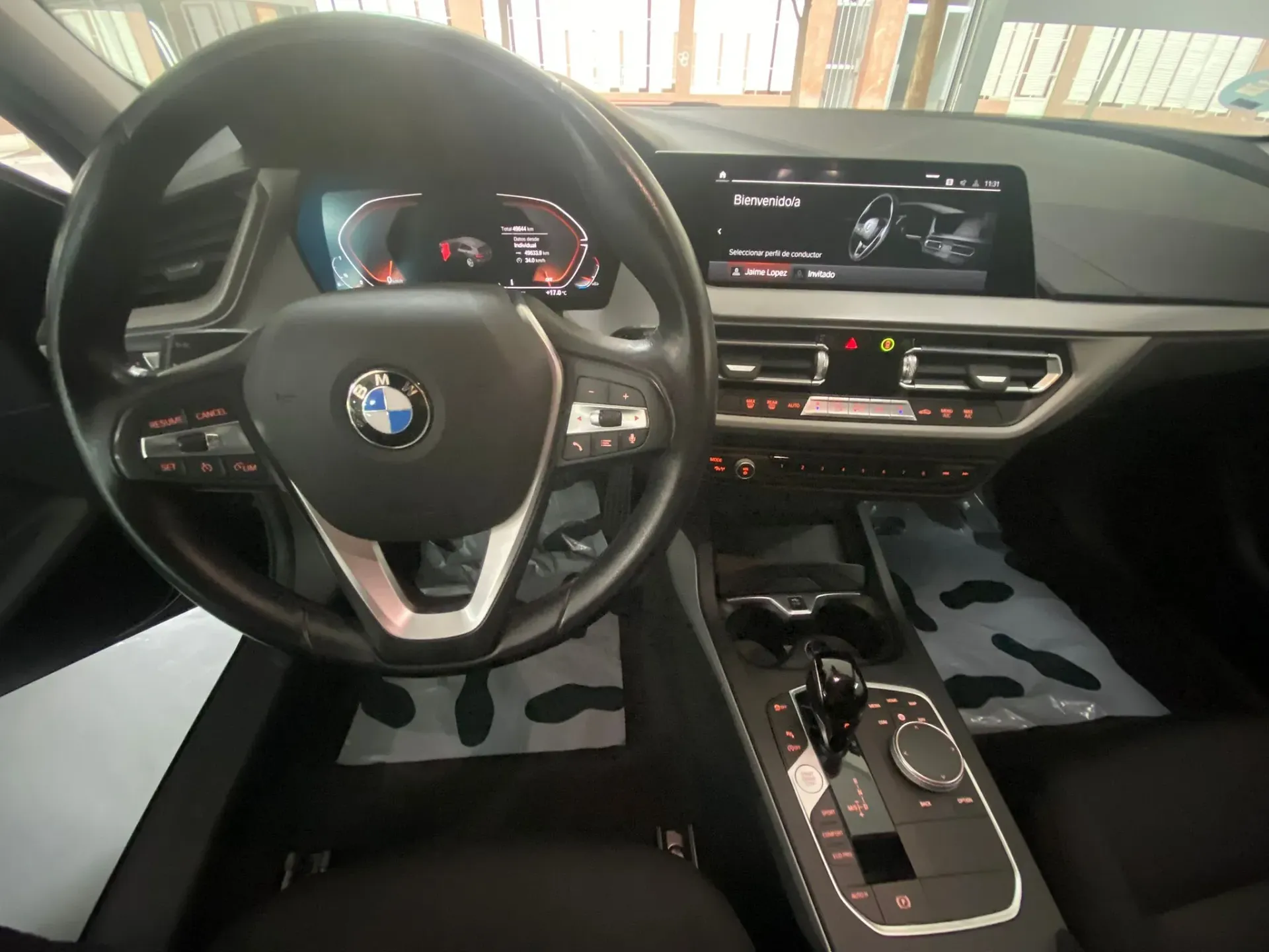 El interior de un coche BMW con volante y salpicadero.