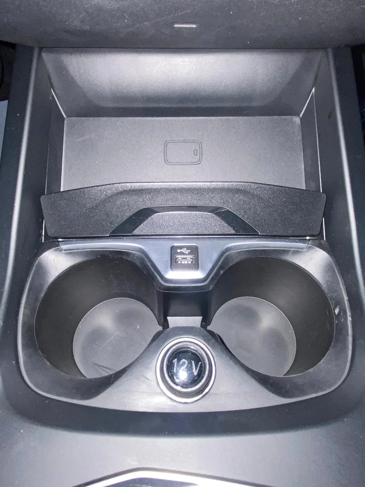 Un portavasos en un coche con una toma de 12 V