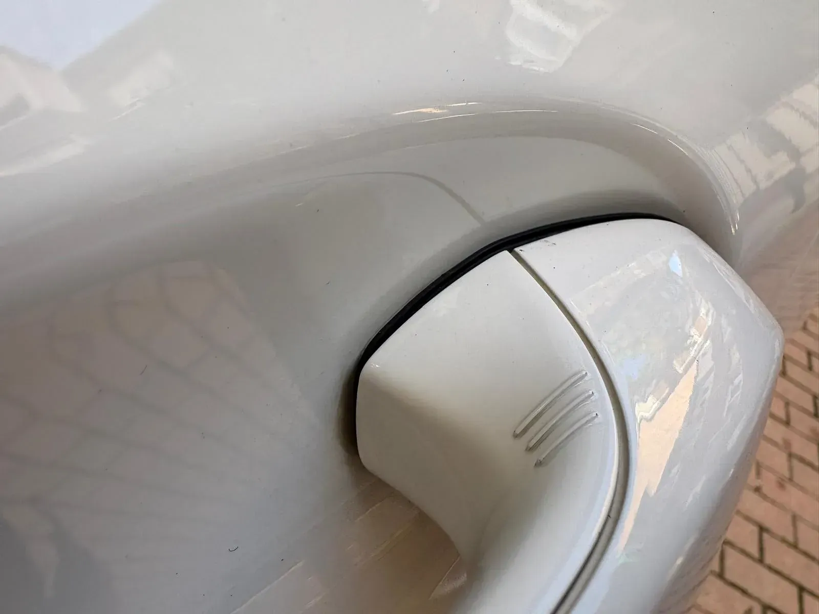 Un primer plano de la manija de la puerta de un automóvil blanco.