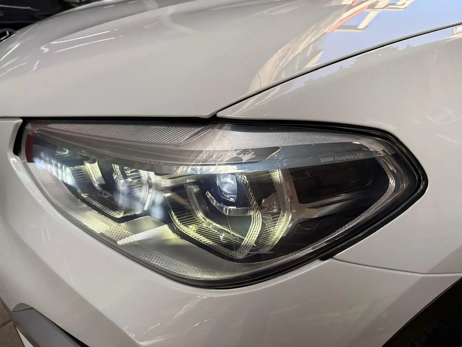 Un primer plano del faro de un coche blanco.