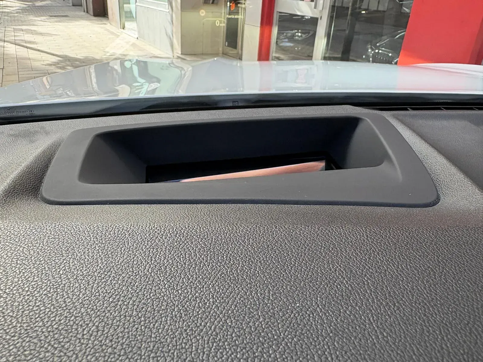 Un primer plano del tablero de instrumentos de un automóvil con un teléfono dentro.