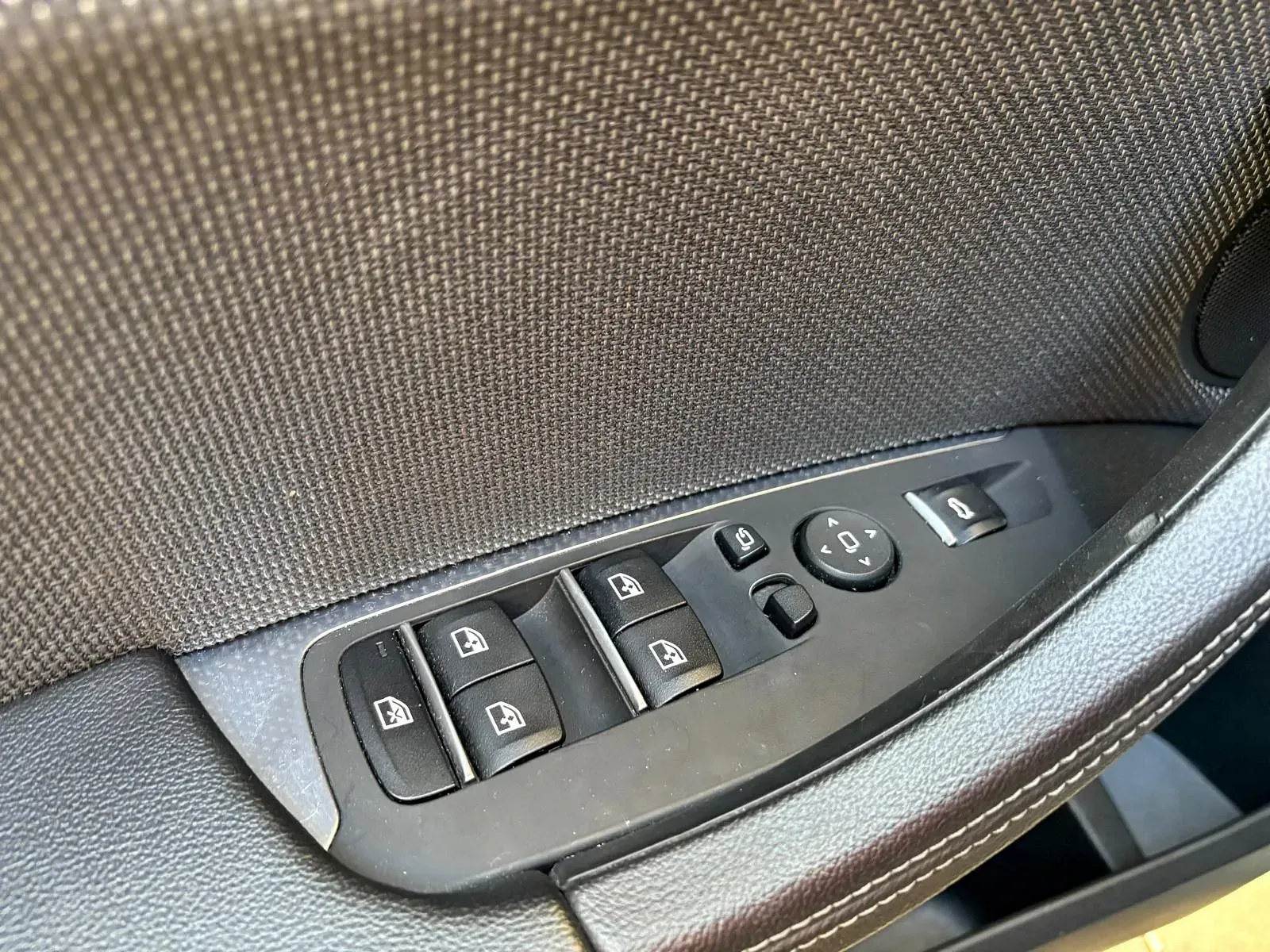 Un primer plano de un panel de control de la puerta de un automóvil.