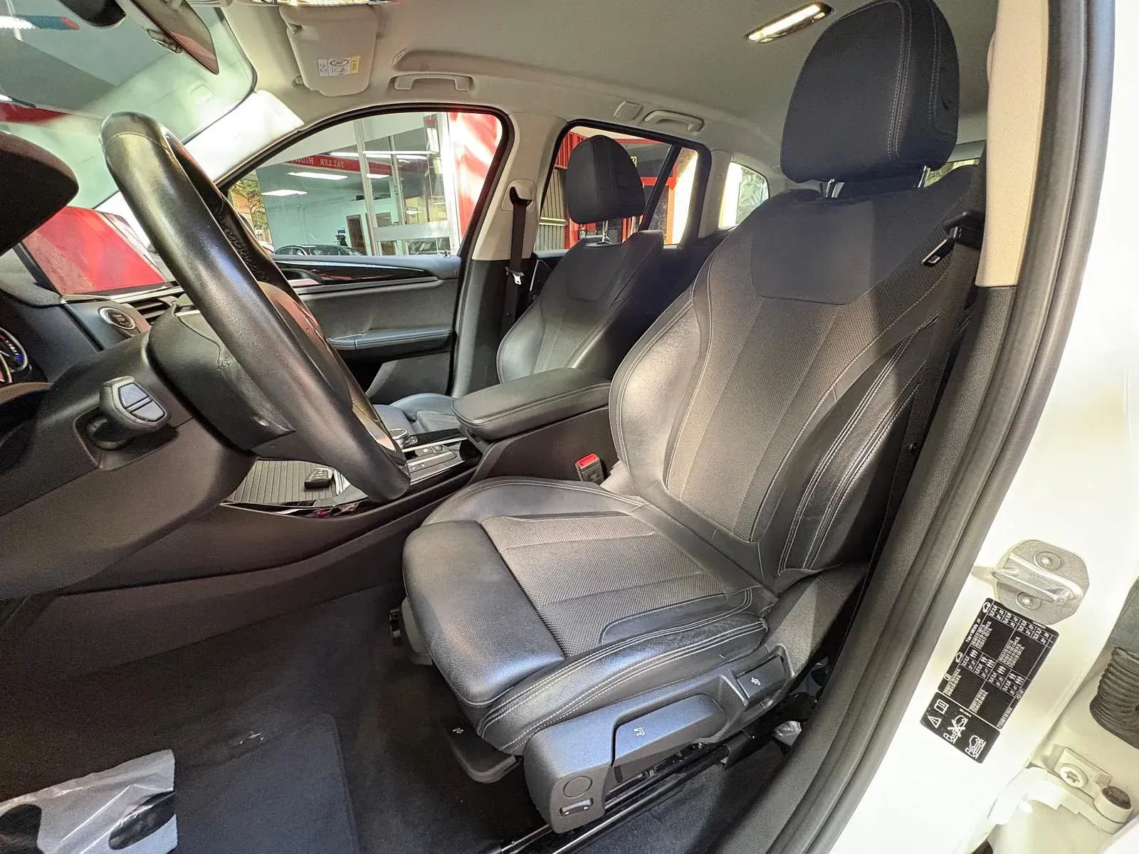 El interior de un coche blanco con asientos negros y un volante.