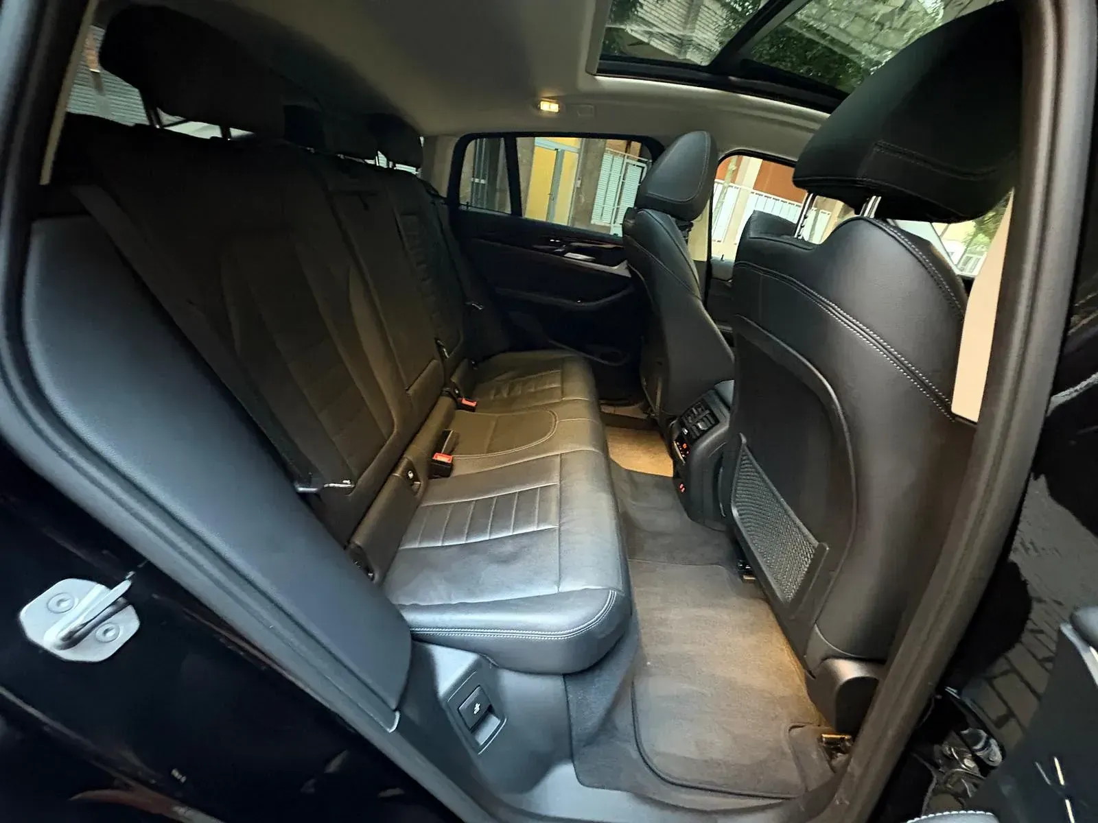 El asiento trasero de un coche negro con techo corredizo.