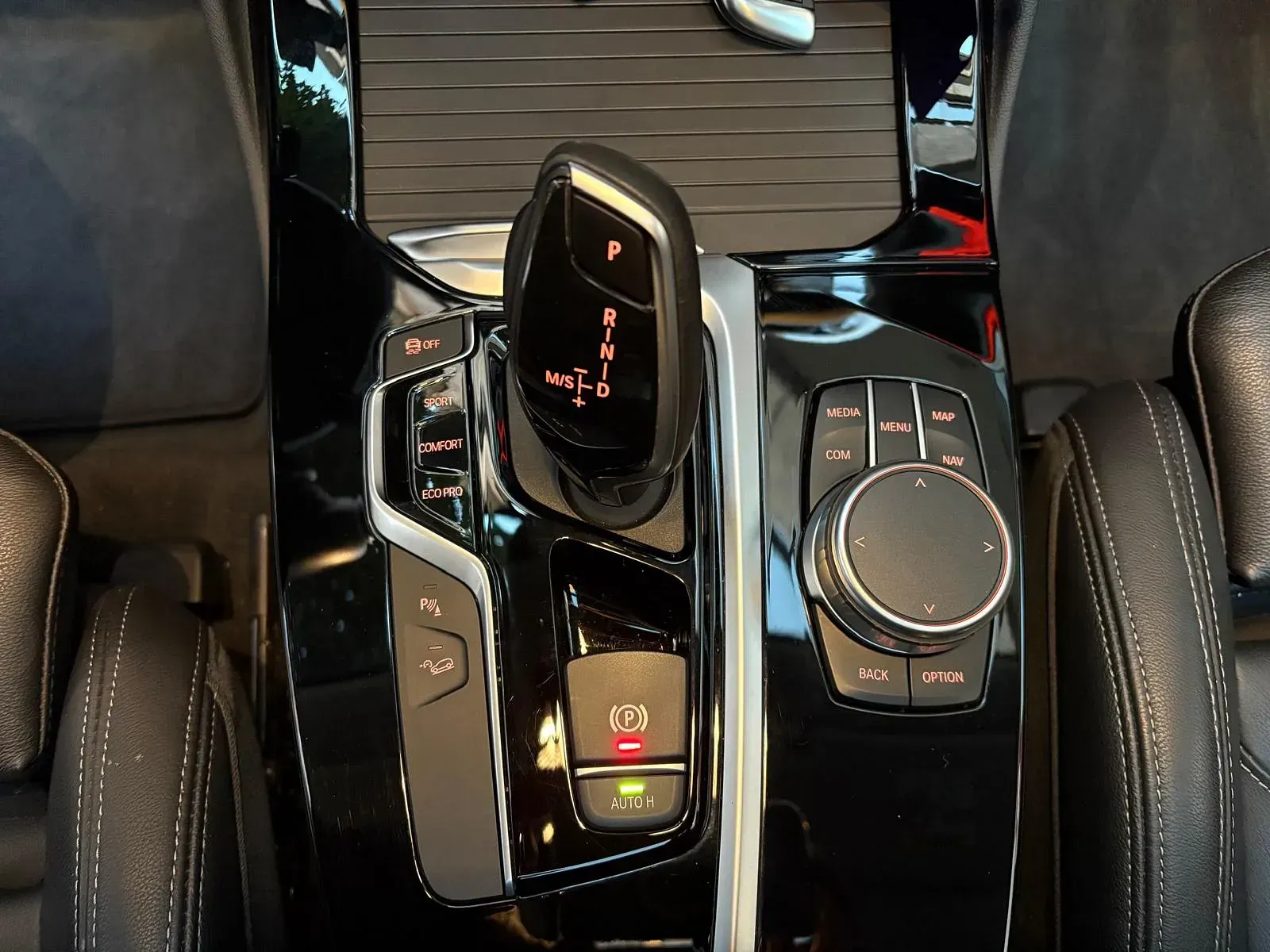 Un primer plano de la palanca de cambios y los controles de un automóvil.