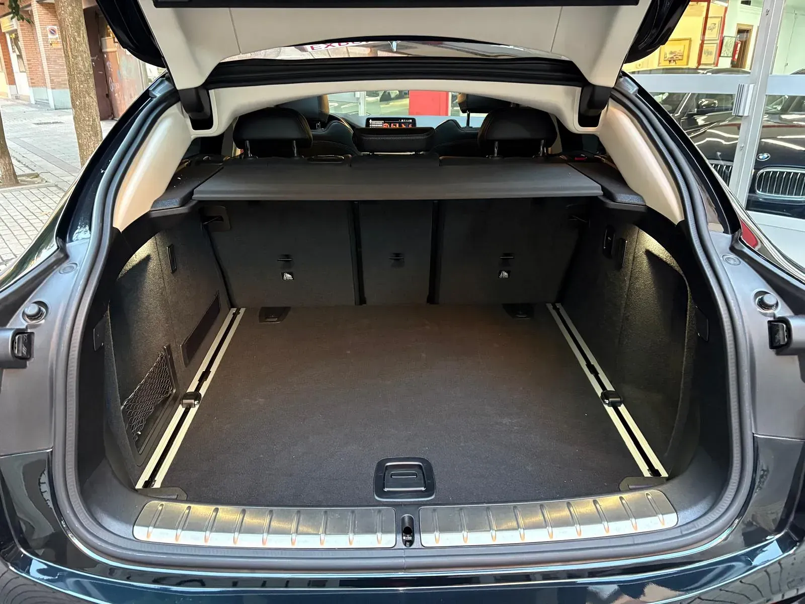 El maletero de un coche negro está abierto y vacío.