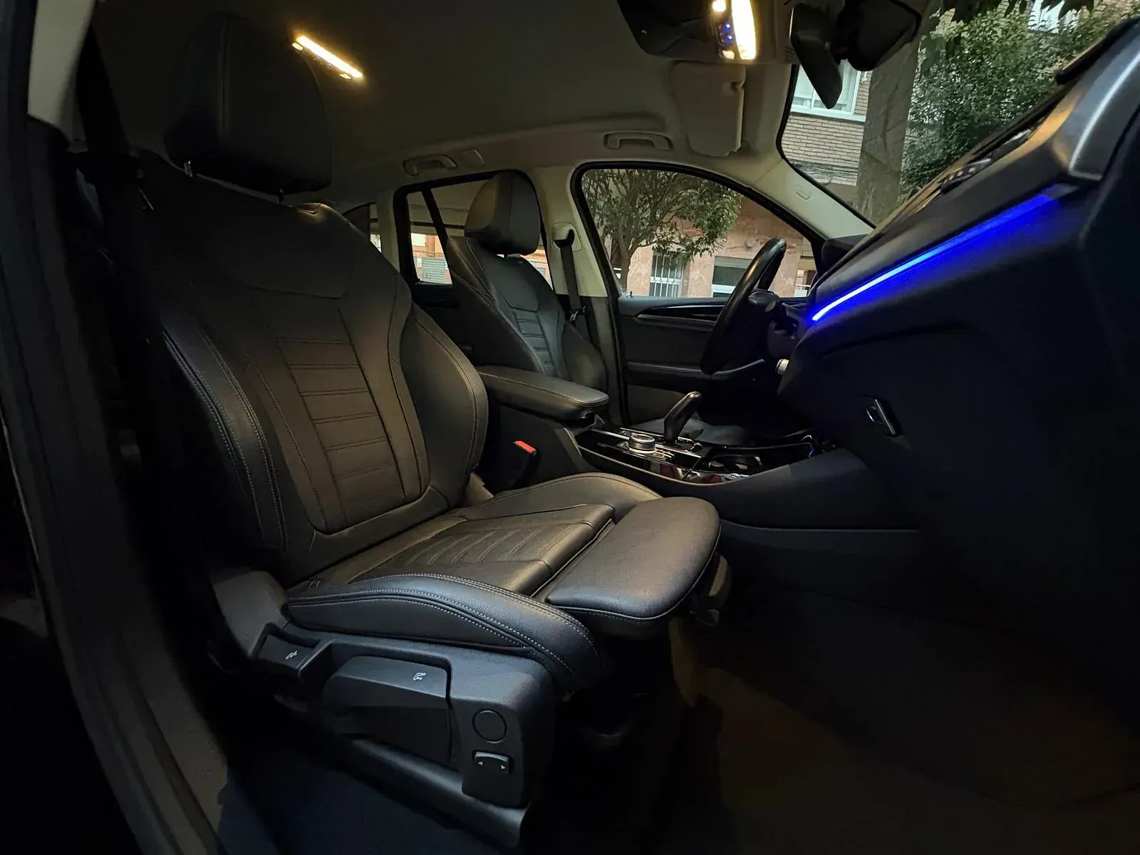 El interior de un coche con una luz azul en el tablero.