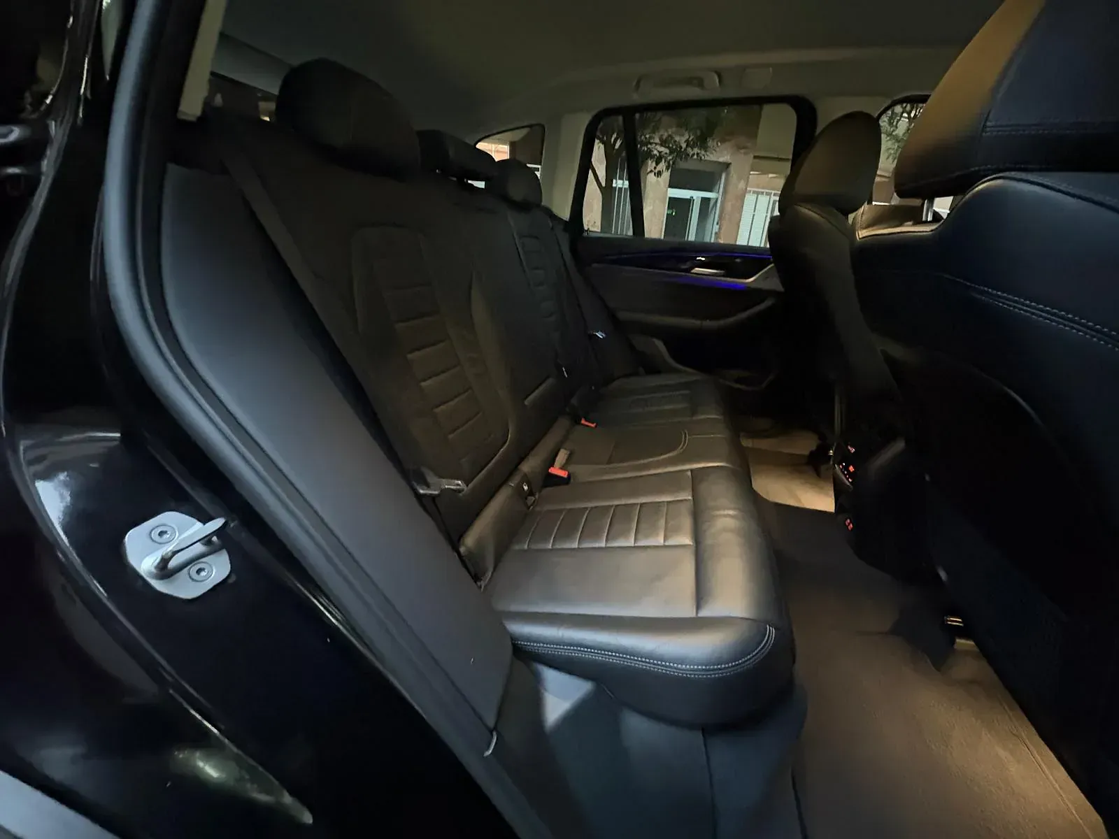 El asiento trasero de un coche negro con la puerta abierta