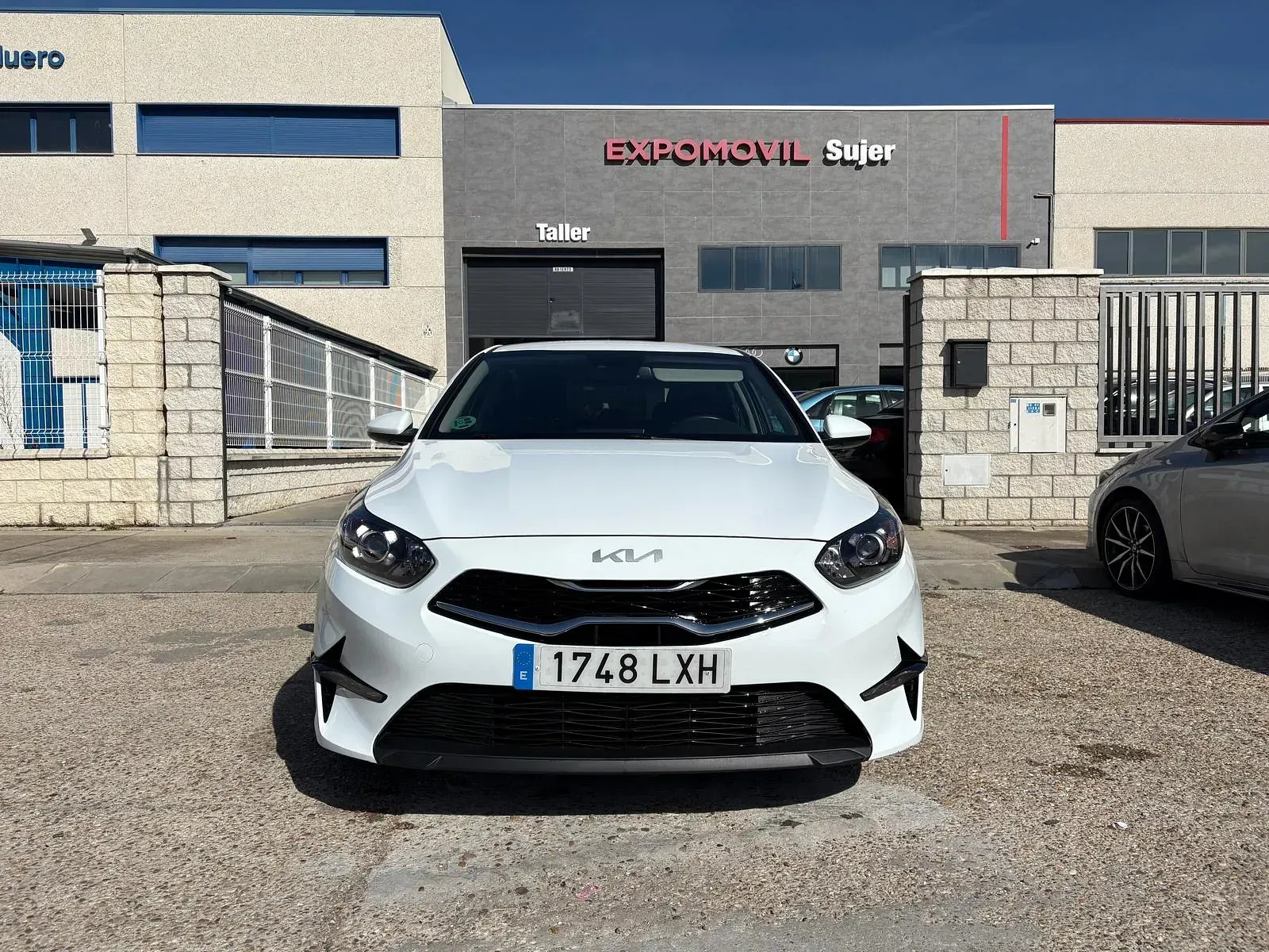Un coche blanco está aparcado delante de un edificio.